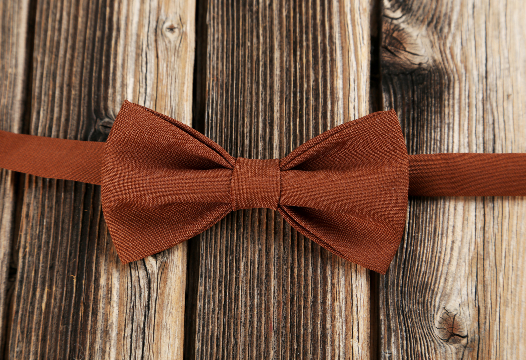 Brown bow tie on a brown wooden table