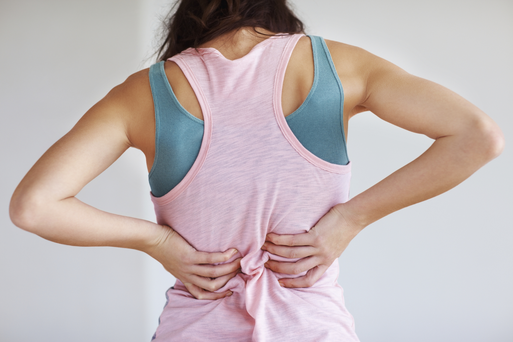 Closeup of young woman suffering from back pain