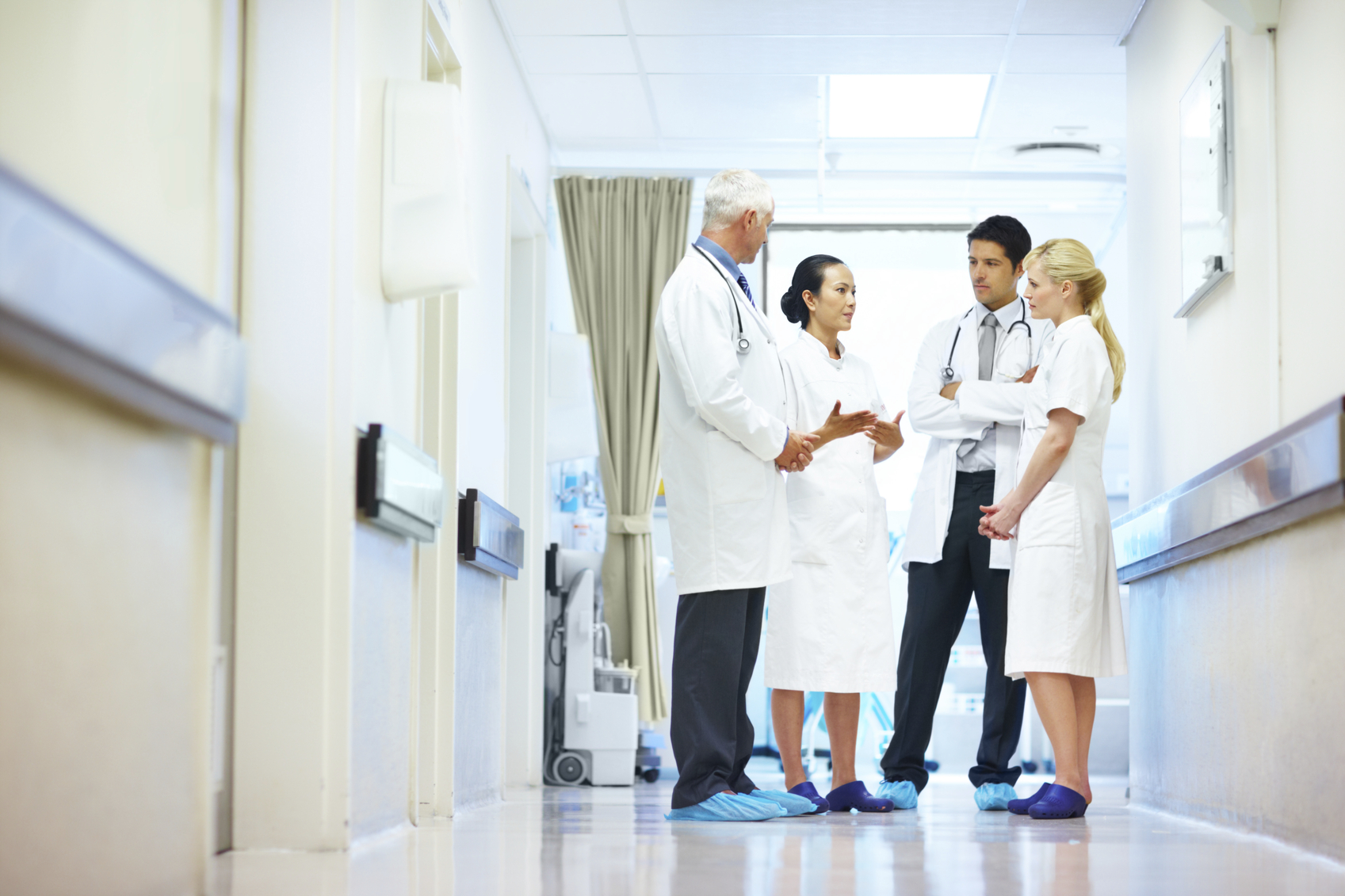 A group of doctors and nurses having a discussion in a hospital corridor
